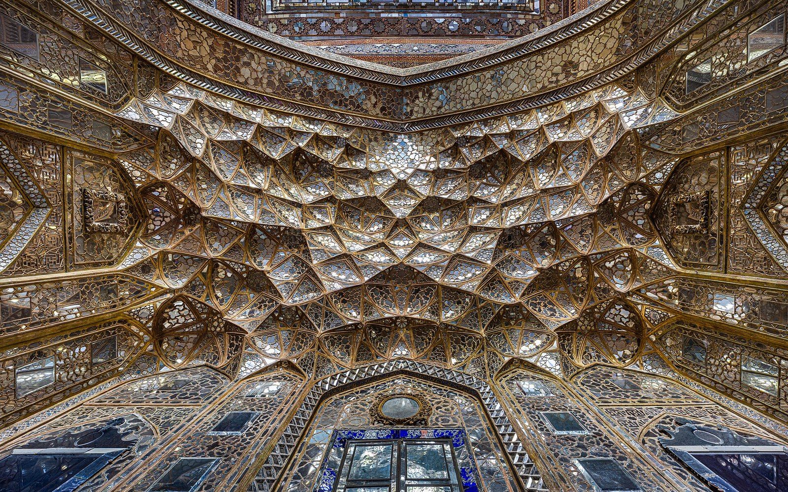 Mirrored muqarnas ceiling with intricate honeycomb vaulting in gold and glass