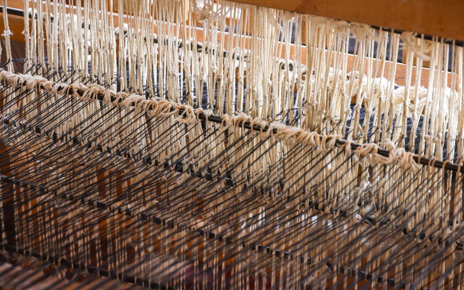 Rows of heddles and knotted threads strung on a traditional weaving loom